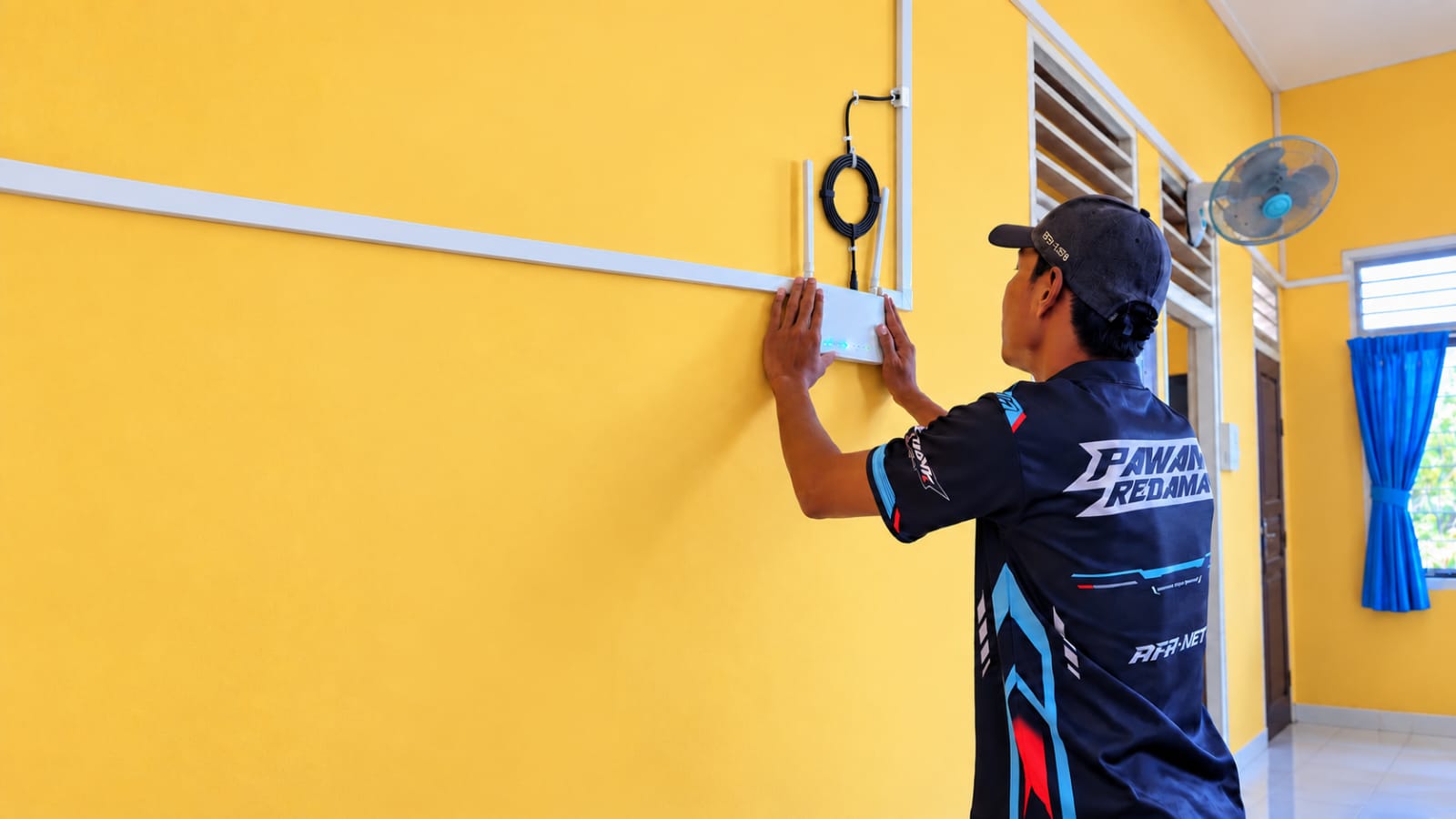 Teknisi AFA NET memasang perangkat WiFi di rumah pelanggan